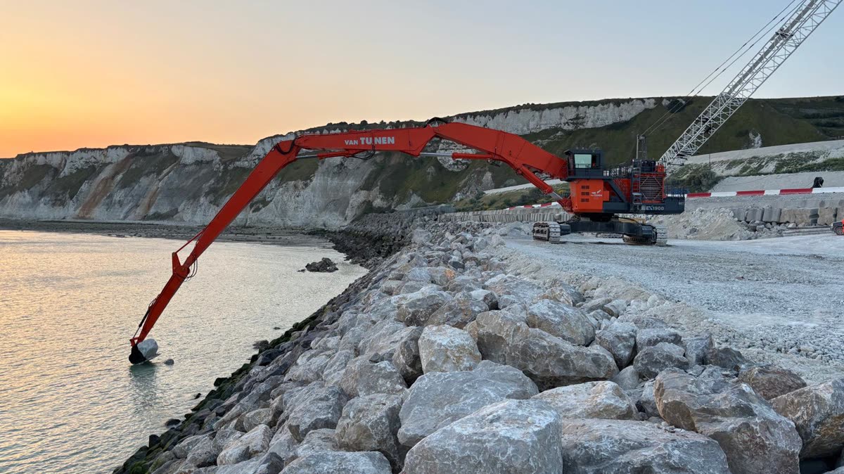 Long-reach excavator placing armour stone at the waterline
