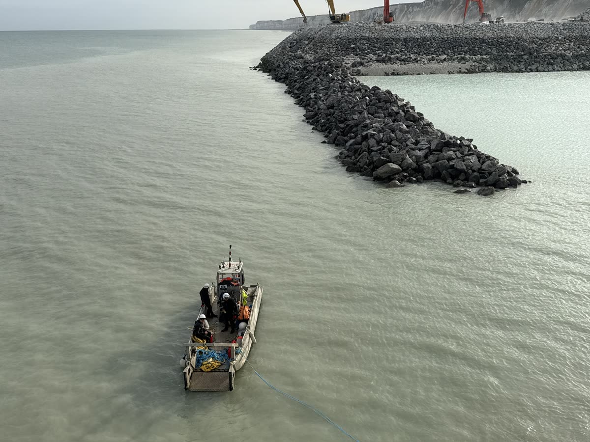 Workboat and crew at the end of a riprap breakwater