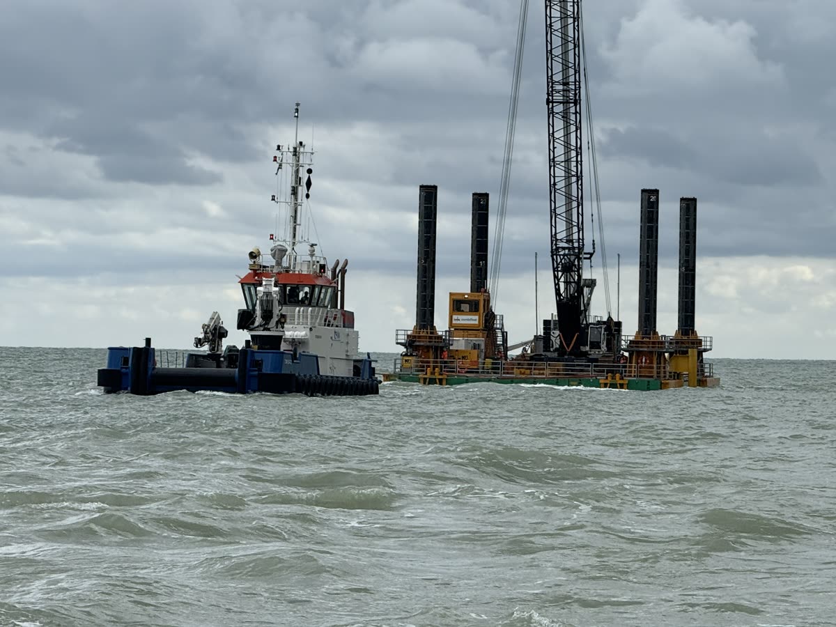 Tugboat moving a jack-up barge with lattice crane