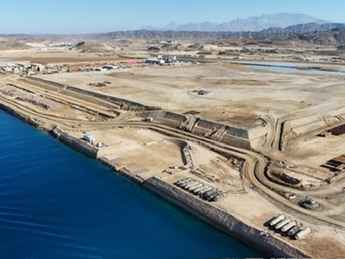 Aerial of coastal earthworks, embankment and stacked pipes