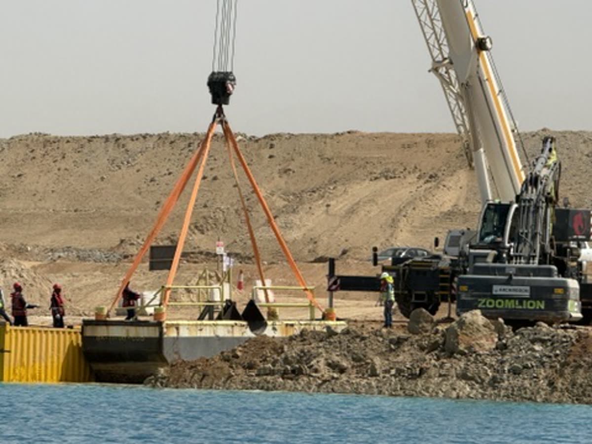 Mobile crane lifting a pontoon at the water's edge