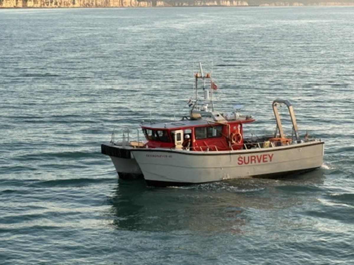 Red and white hydrographic survey catamaran underway